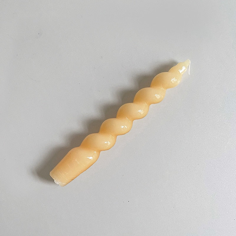 Single twisted pillar candle with a light yellow colour.