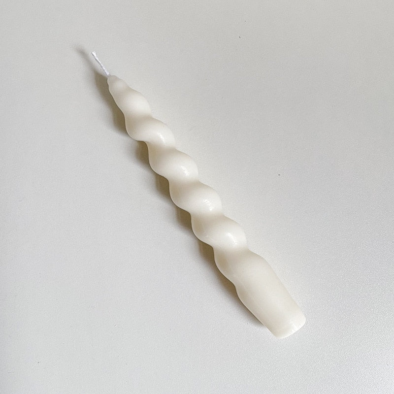 Single twisted tapered candle with a creamy white colour.