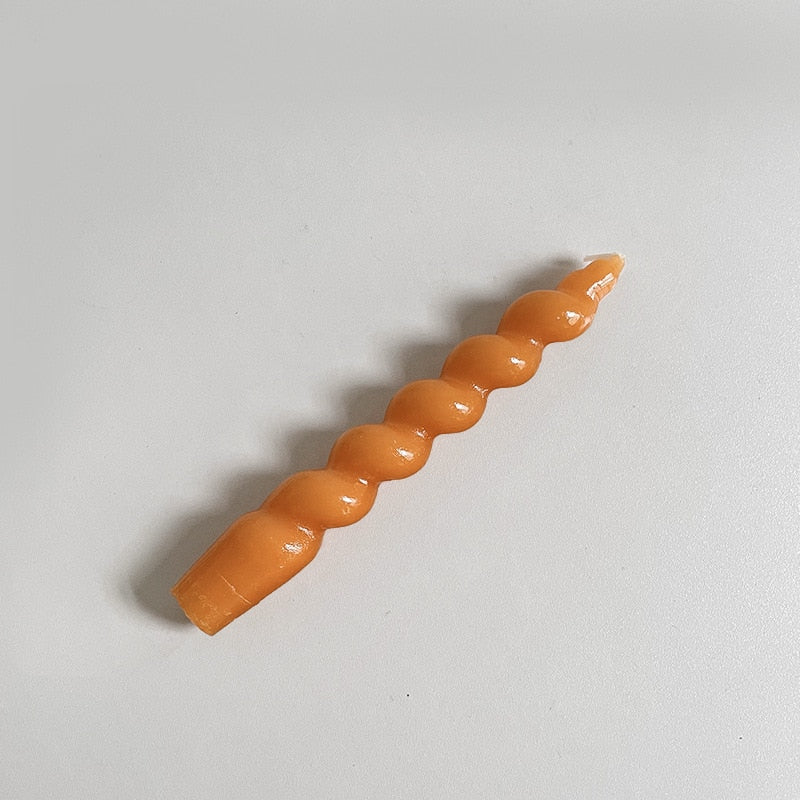 Single twisted tapered candle with a rich burnt orange colour.