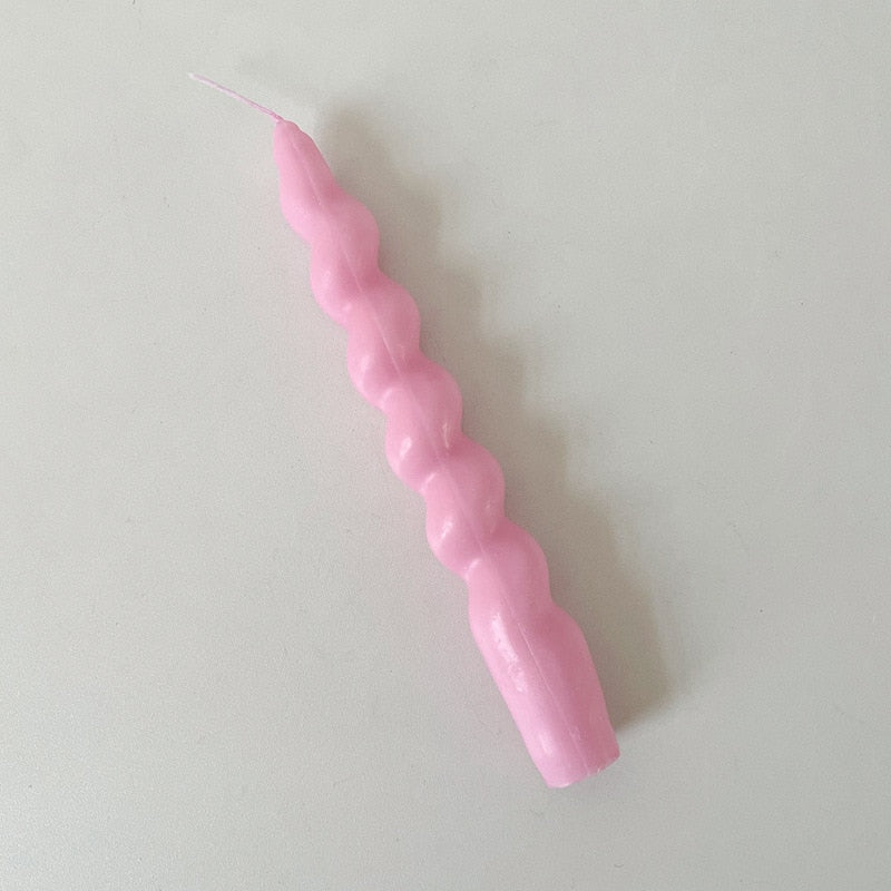 Single twisted tapered candle with a rich pink colour.