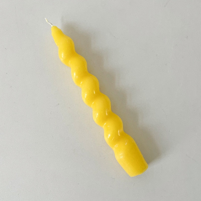 Single twisted tapered candle with a rich yellow colour.